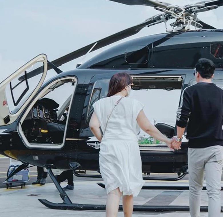 Pareja abordando un helicóptero negro de lujo