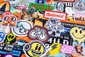 Colorful assortment of custom stickers — mushrooms, bikes, smiley faces, optimist text, and various artistic designs
