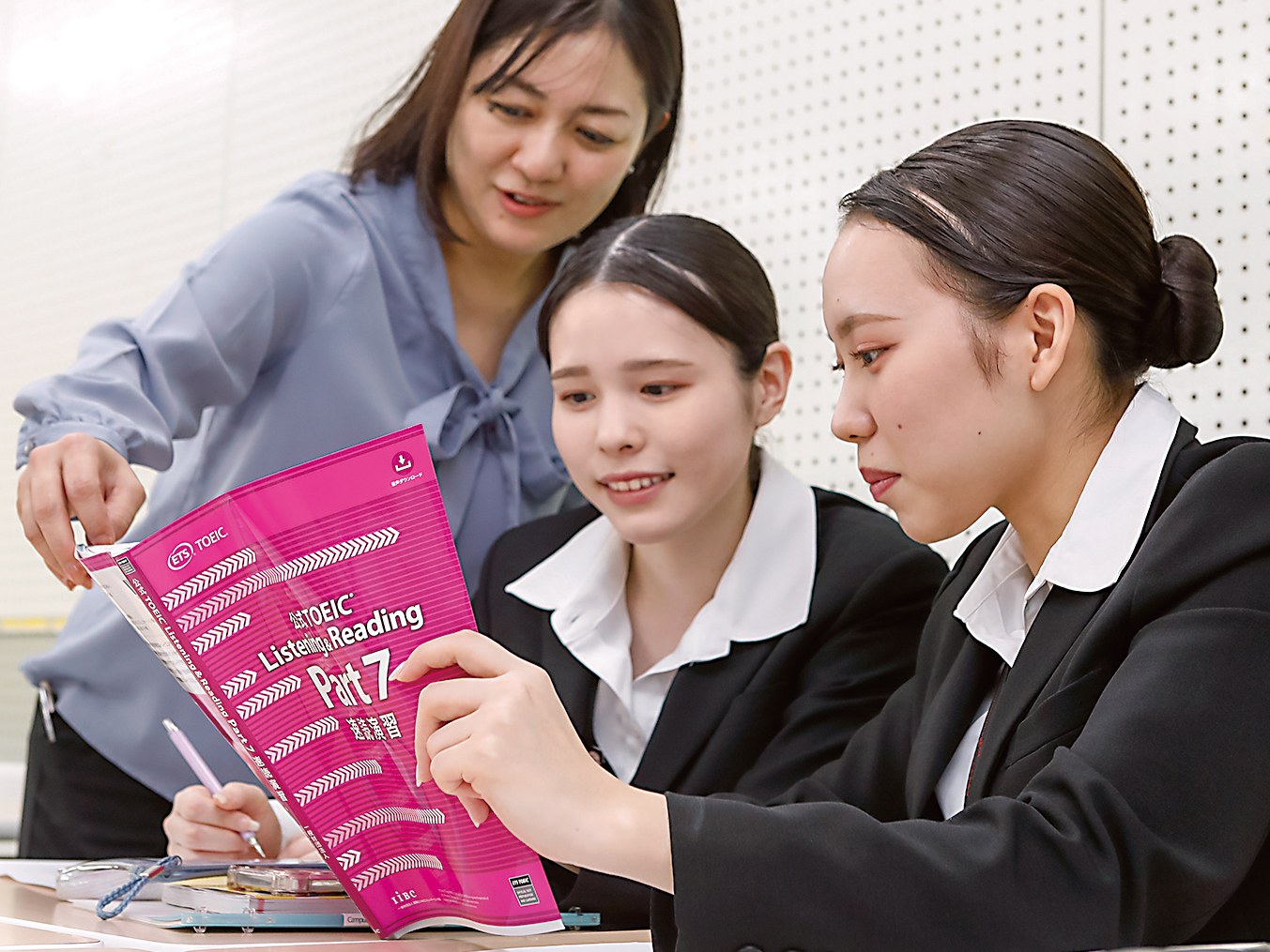 先生と学生がTOEIC教材を一緒に確認している授業の様子