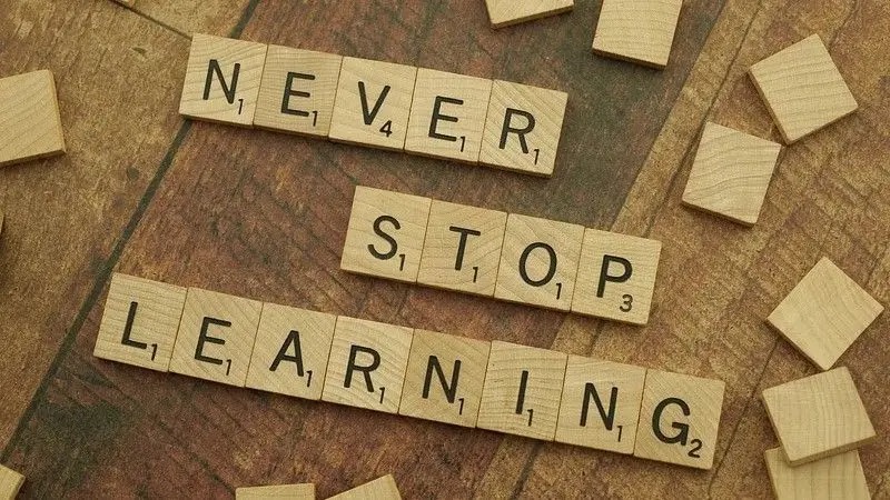 Scrabble tiles spelling Never Stop Learning