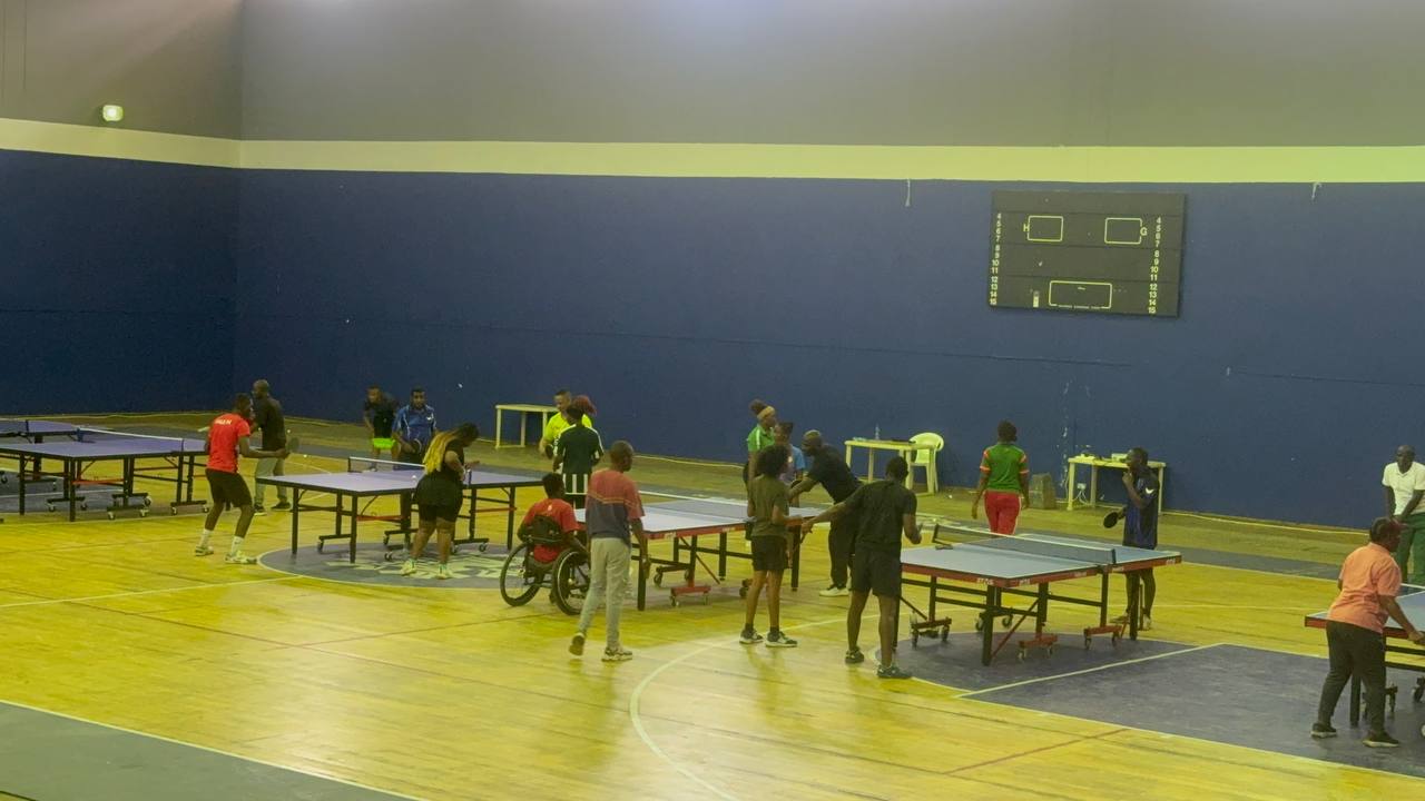 Multiple table tennis tables in use during training at the National Sports Development Centre