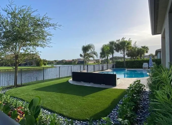 Tropical pool landscape with artificial turf and palm trees in Palm Beach County
