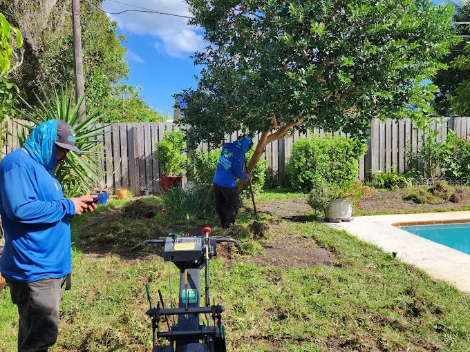 Integrity Landscape crew preparing and grading a residential backyard near a pool for new sod installation