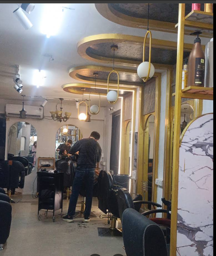 Gold-accented Kaizen salon interior with barber at work