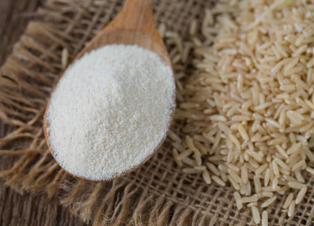 Rice flour in a wooden spoon with rice grains