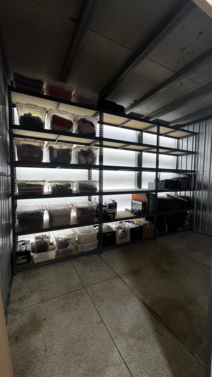 Interior de box com prateleiras metálicas para armazenamento organizado