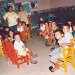 Kinder auf bunten Stühlen im Klassenraum