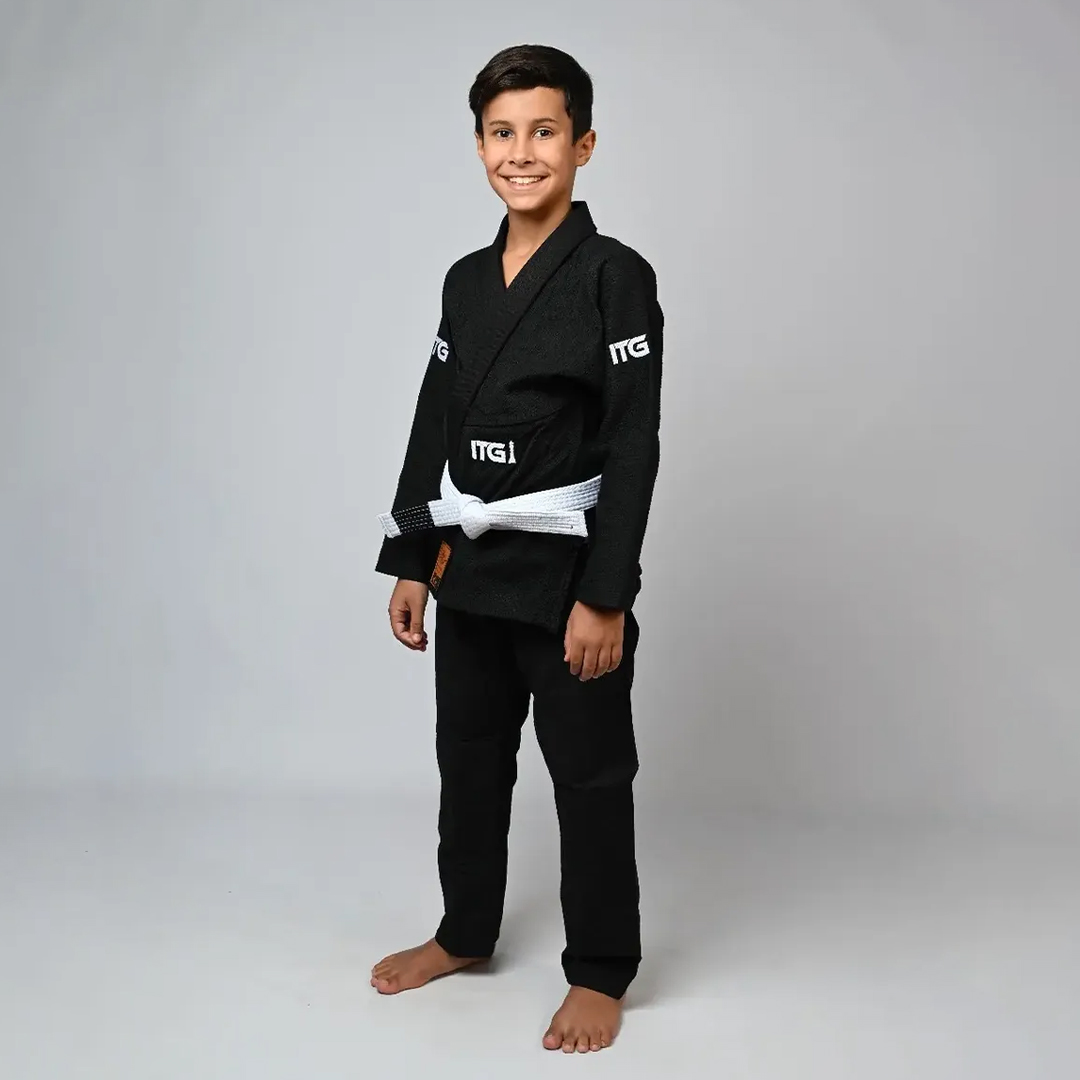 Kimono de Jiu-Jitsu Infantil In The Guard preto, tecido macio resistente com costuras reforçadas — criança em posição de luta com faixa branca