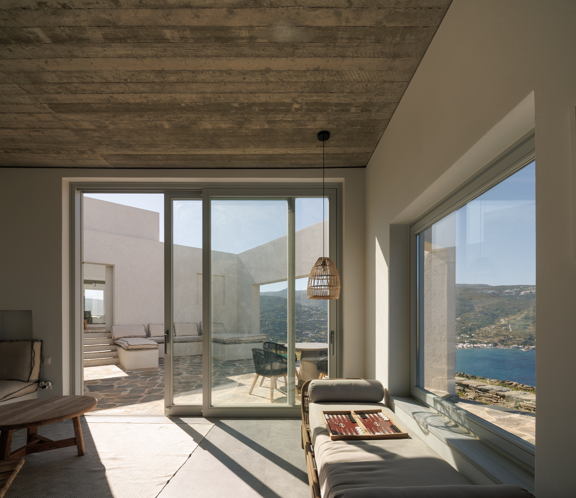 Sunlit interior with rattan daybed and sliding doors to the courtyard