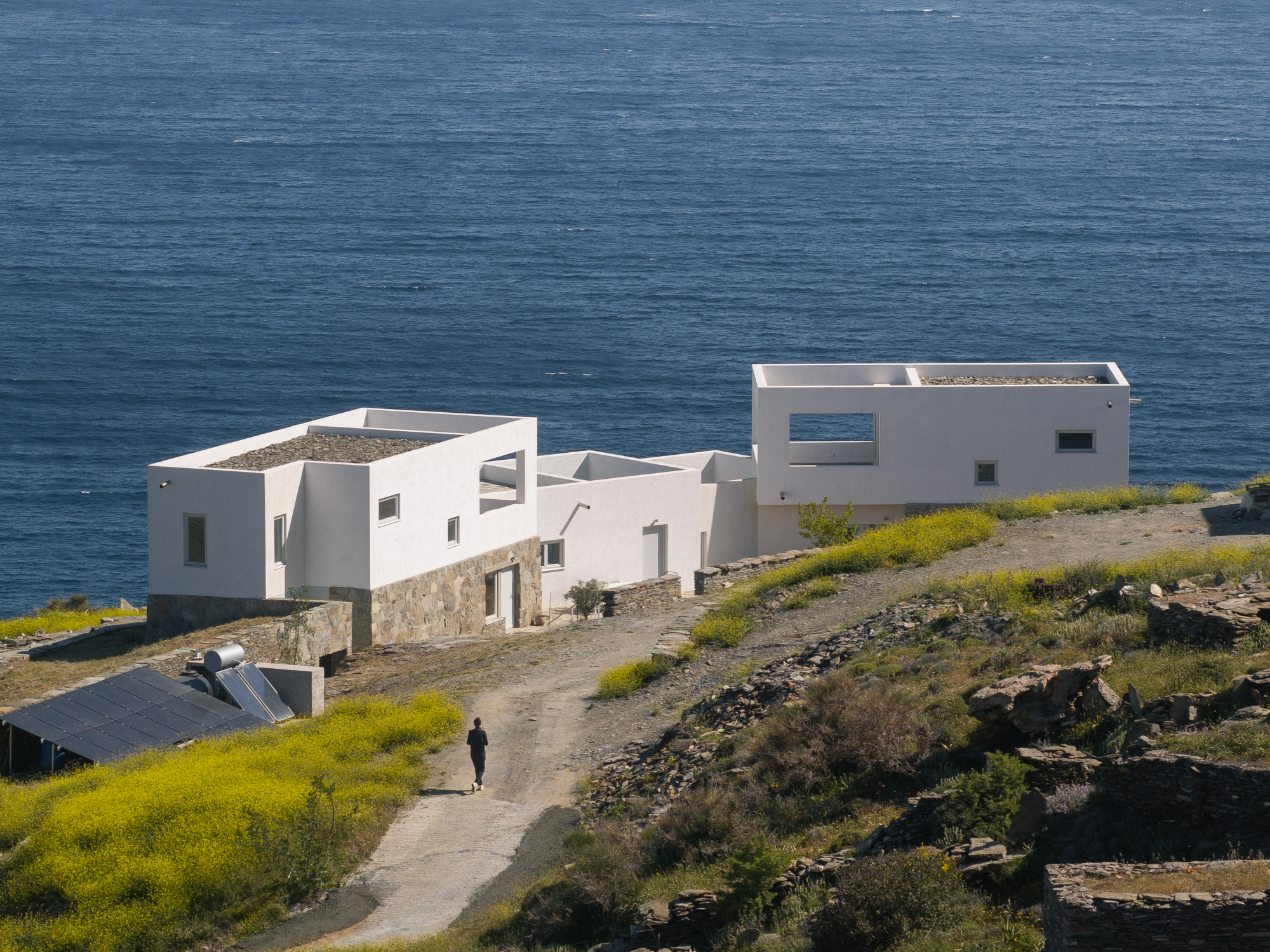 Aerial view of the houses above the sea with a figure on the path