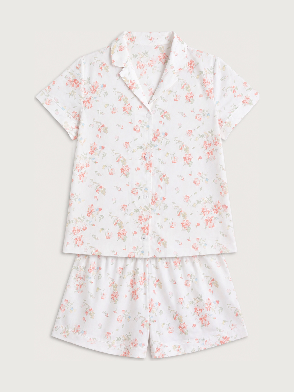 A satin coordinated short-sleeve button-front top and shorts with an all-over pink floral pattern.