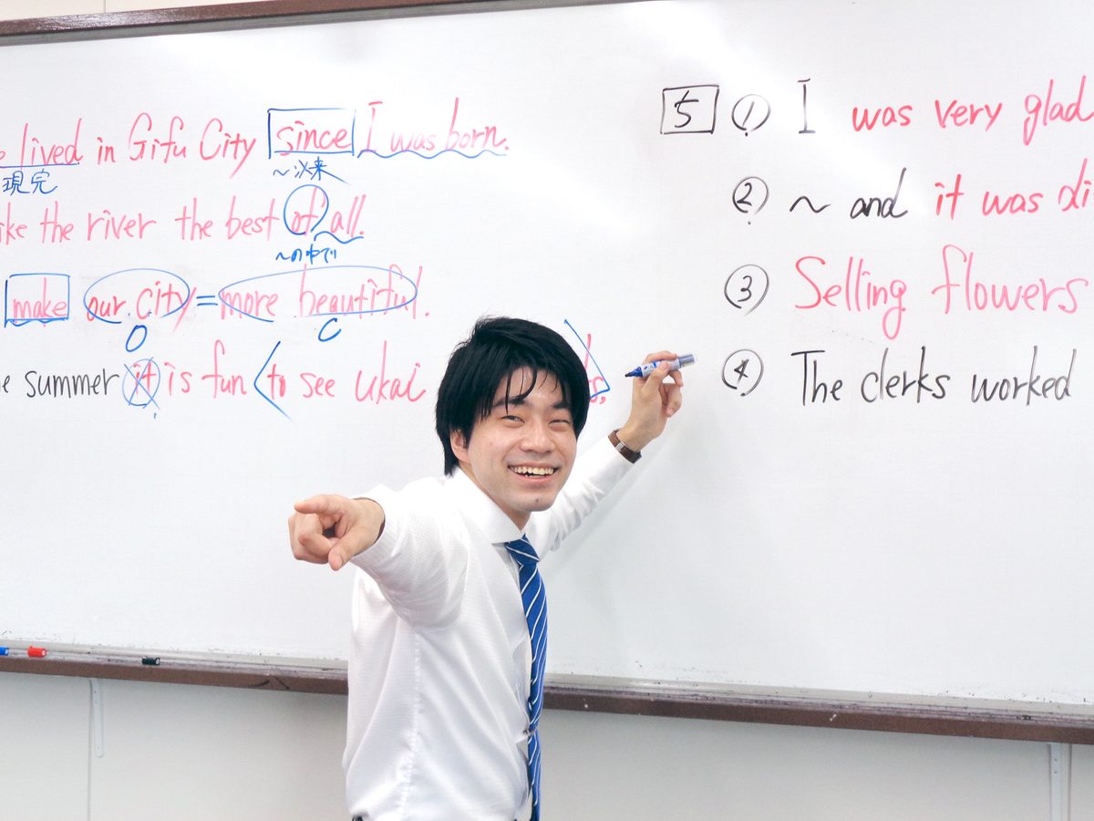 ホワイトボードで英作文の添削ポイントを解説する講師