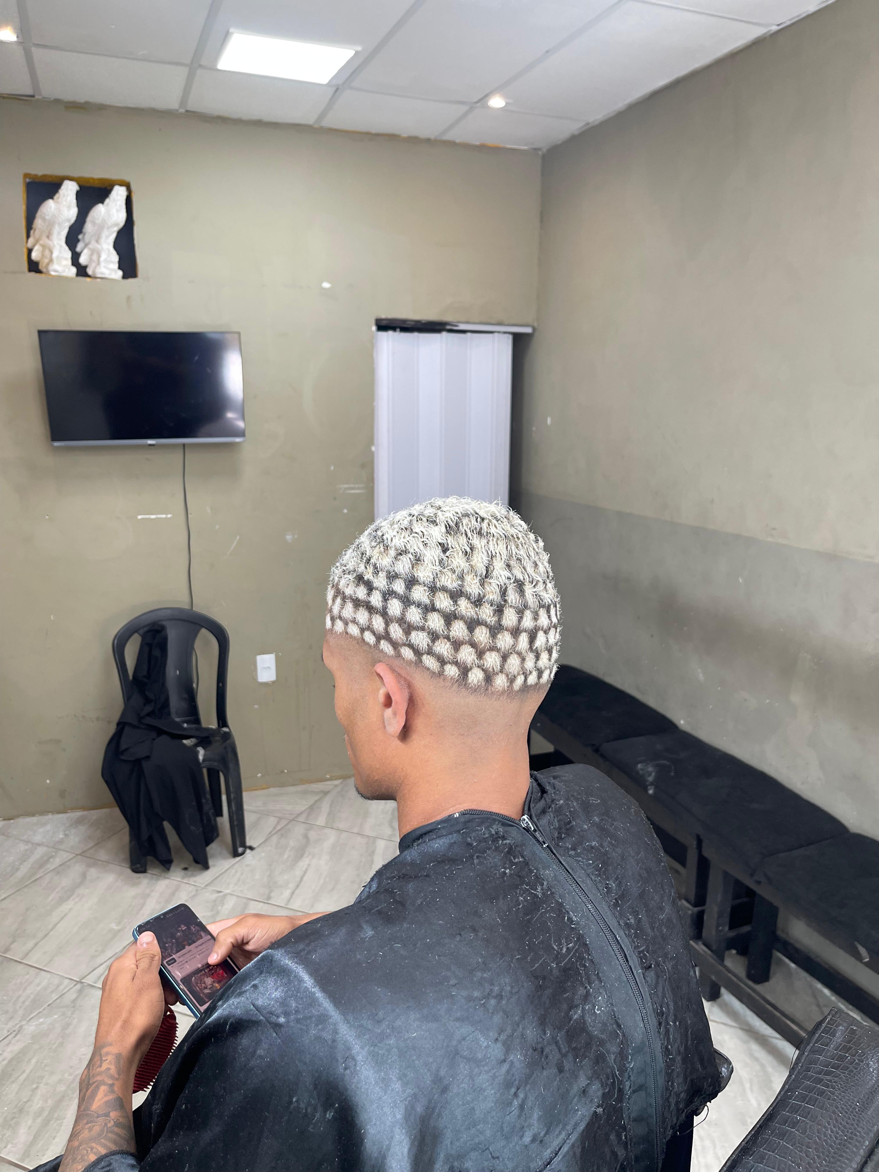 Cliente sentado na cadeira da barbearia