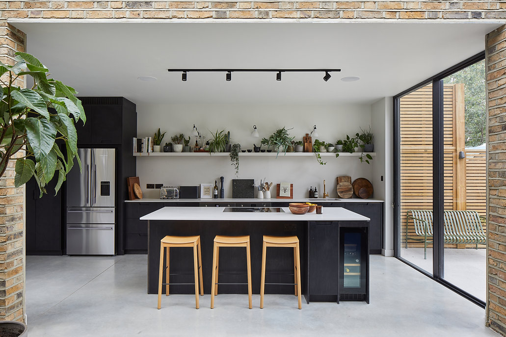 Contemporary kitchen with black cabinetry, white countertops, and wooden bar stools