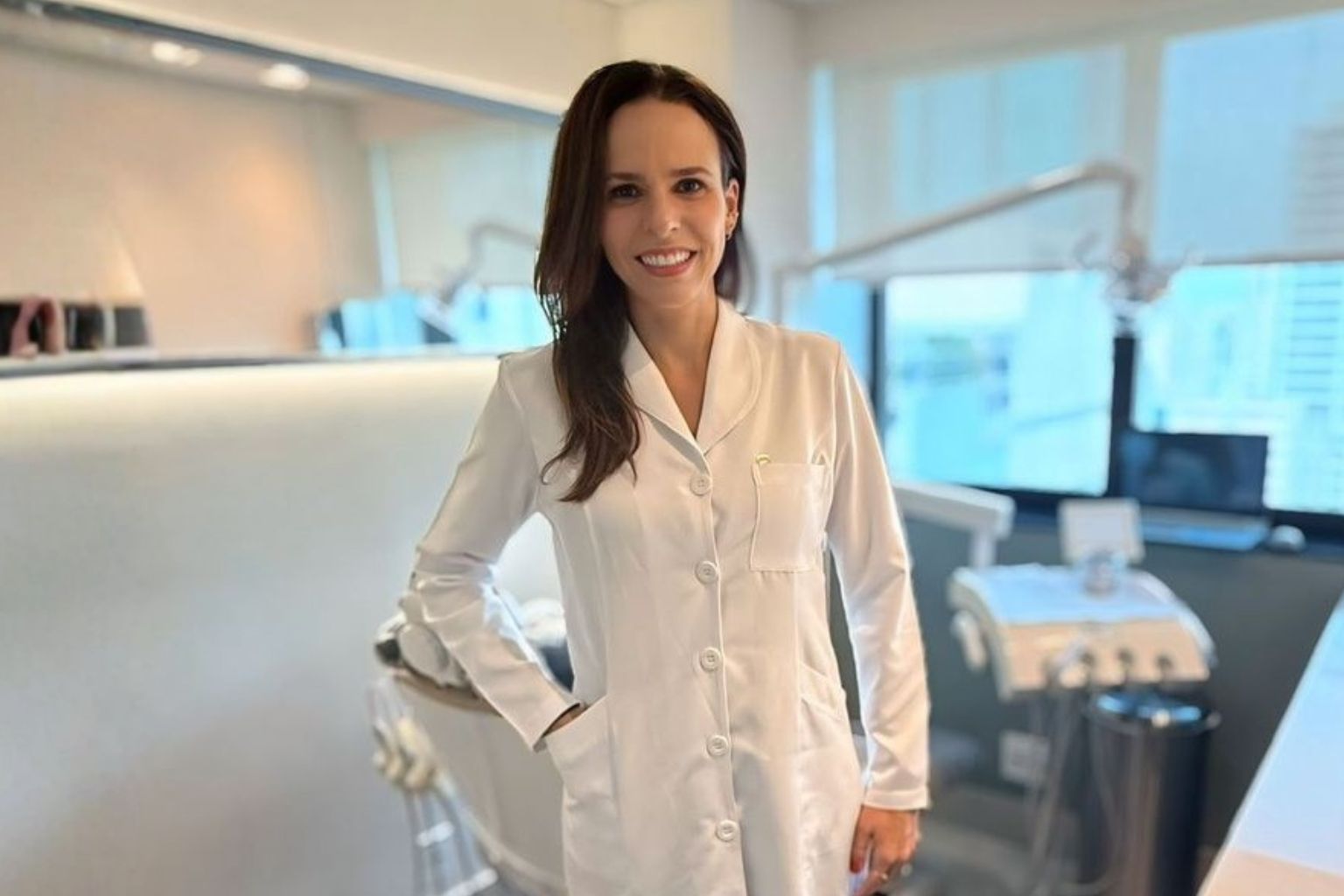 Dra. Luciana Thomaz de jaleco branco no consultório