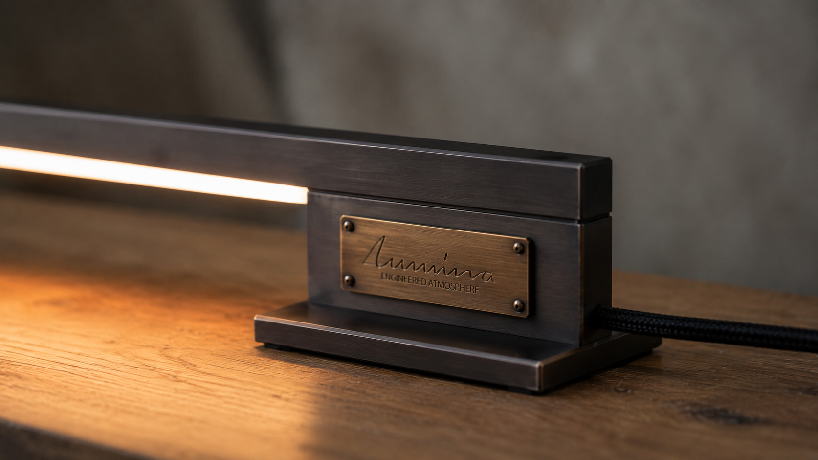 Lumina-Leuchte mit warm beleuchteter Messingplakette auf einem Holztisch