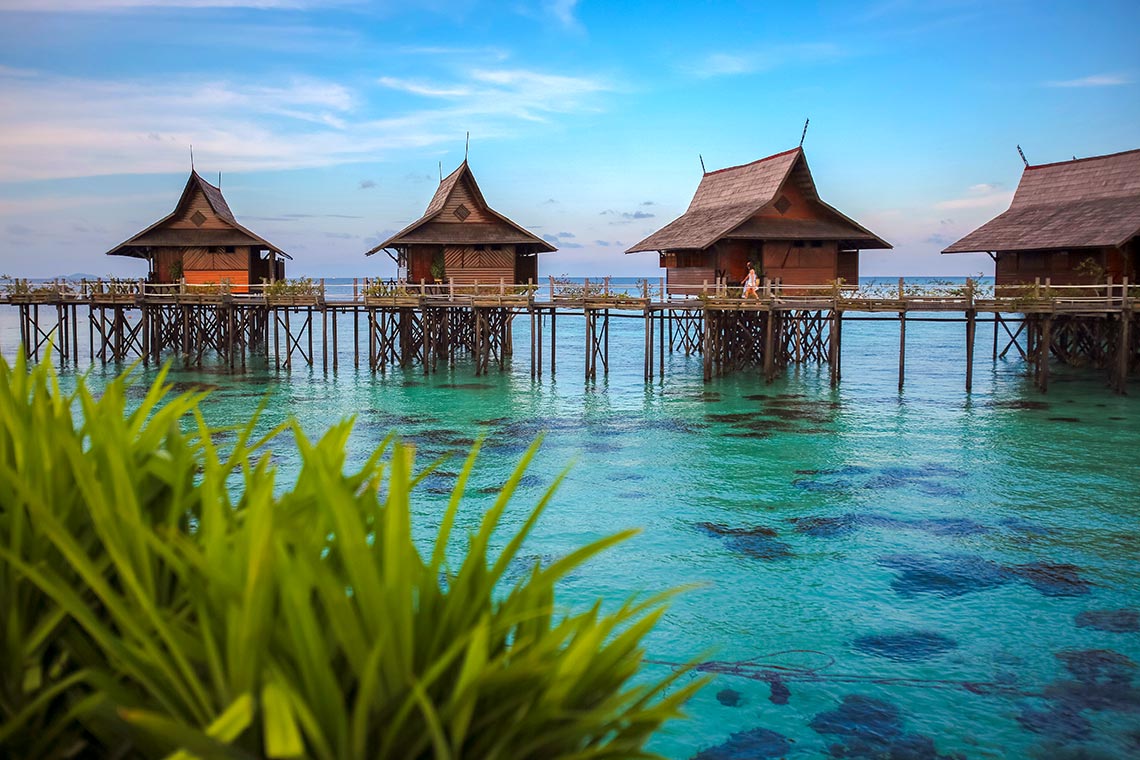 Over-water bungalows on stilts above turquoise sea at Mabul Island, Sabah, Malaysia