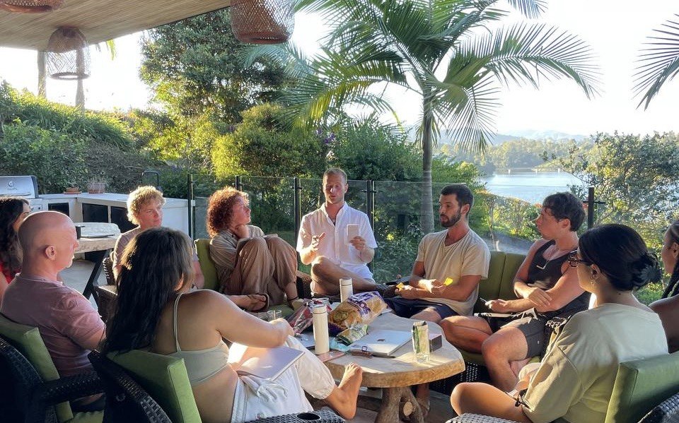 Retreat participants sharing a conversation on a tropical terrace