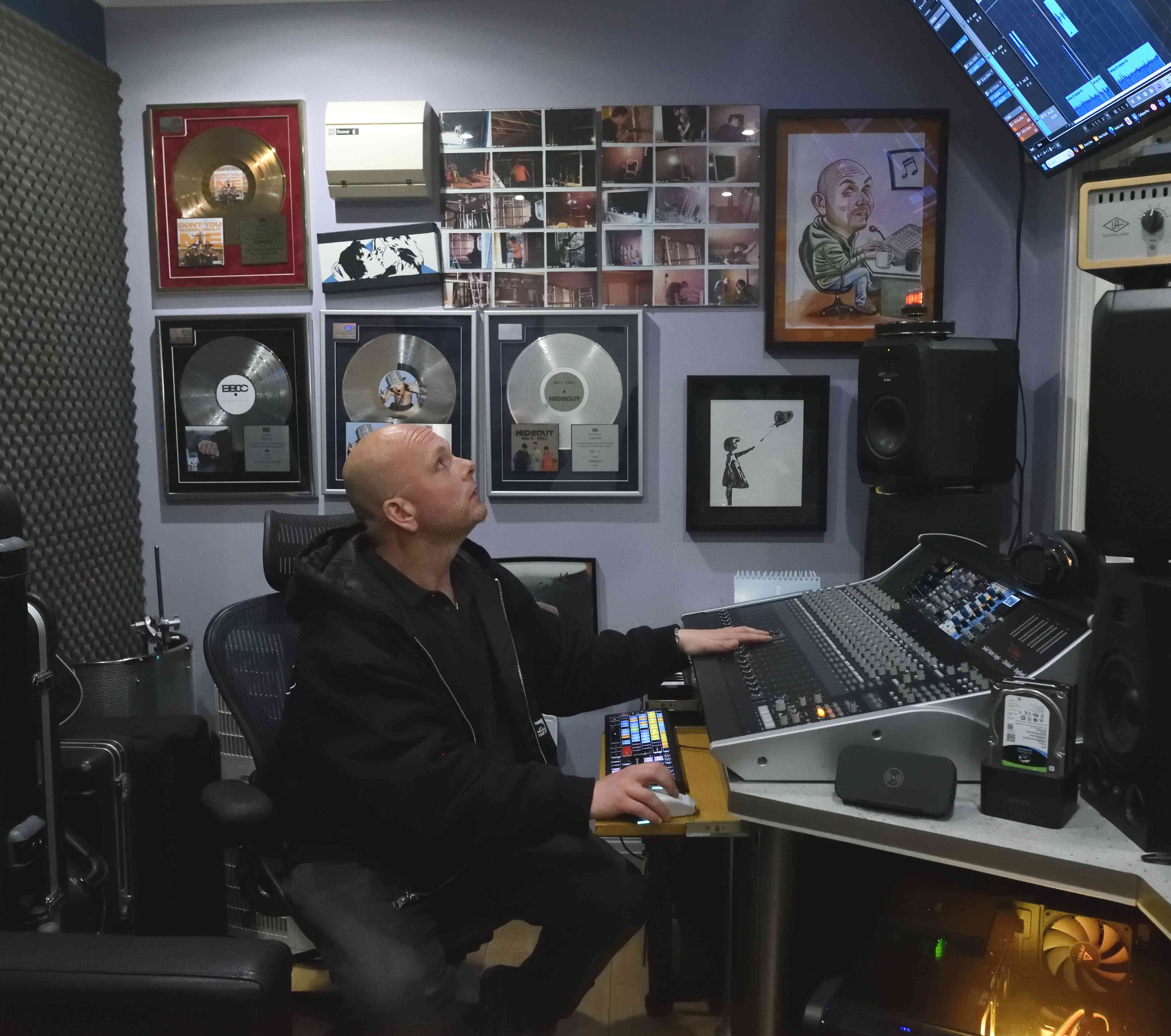 Tom Fox at Moorcroft Studios mixing desk surrounded by gold and platinum record plaques