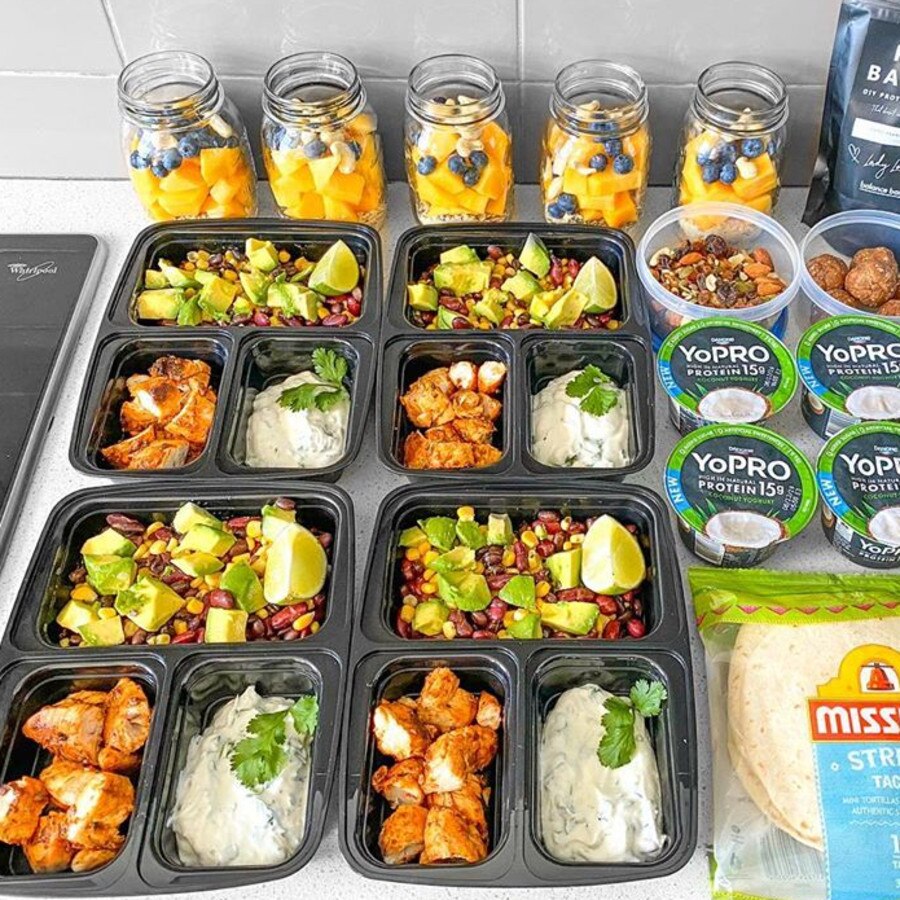 Professional meal prep setup showing prepared meals and ingredients