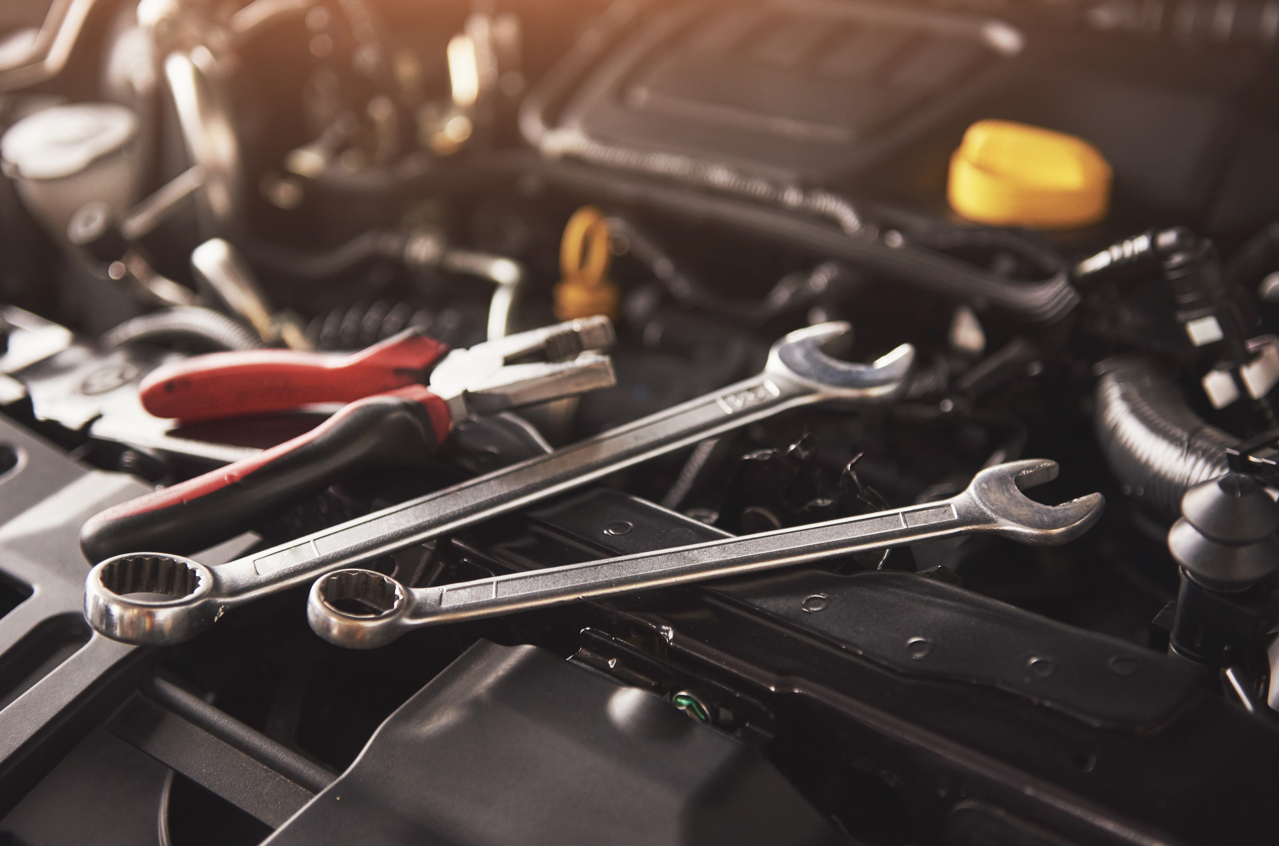 Mechanic tools laid across car engine