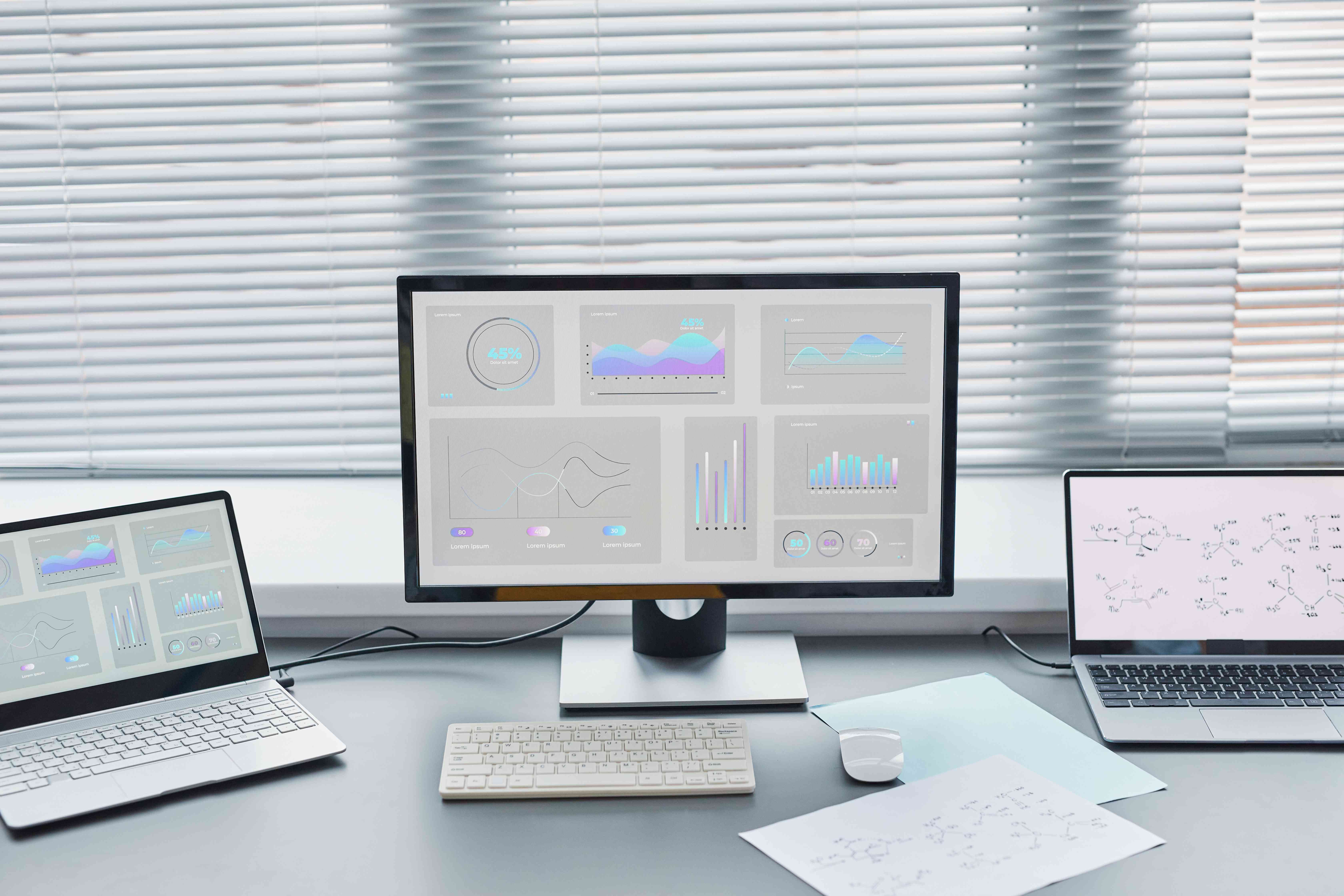 Desk with laptops and analytics screens representing faster contract review