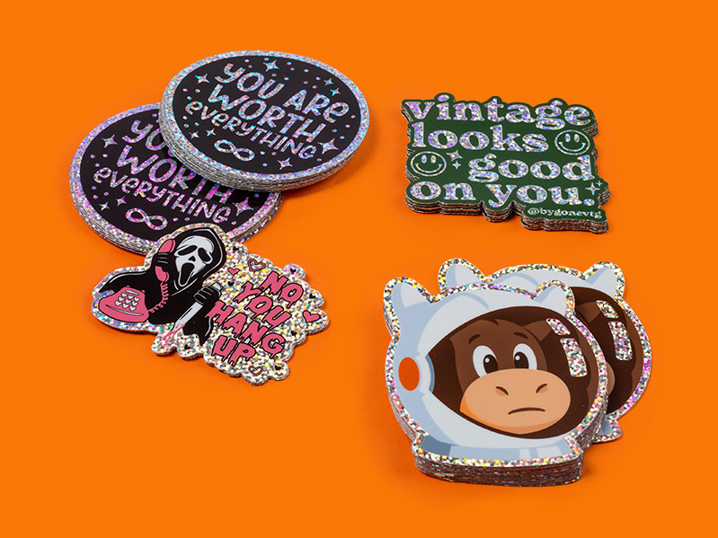 Glitter stickers on orange background with You Are Worth Everything, scream, and astronaut mule designs