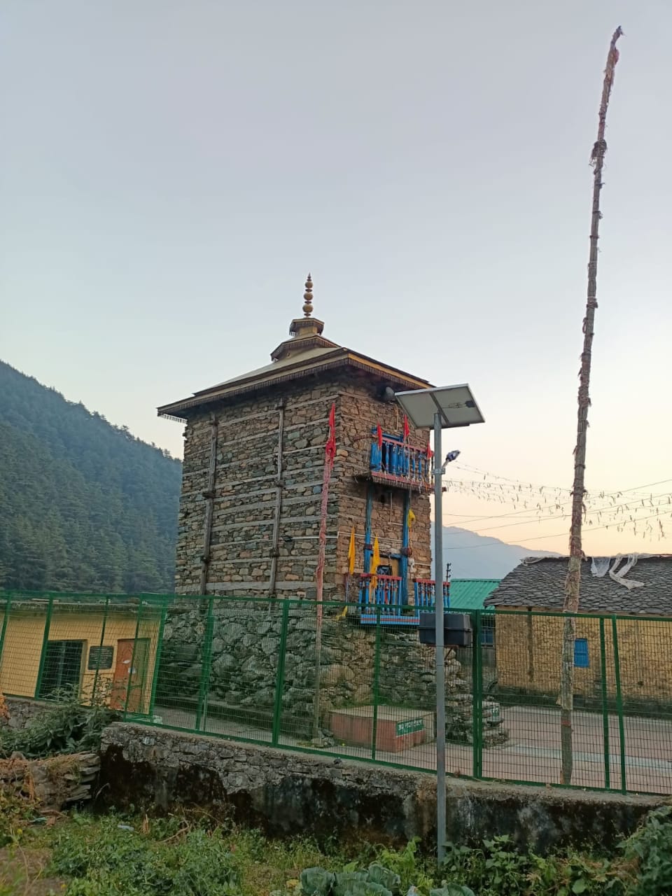 Traditional stone temple with mountain backdrop at sunset