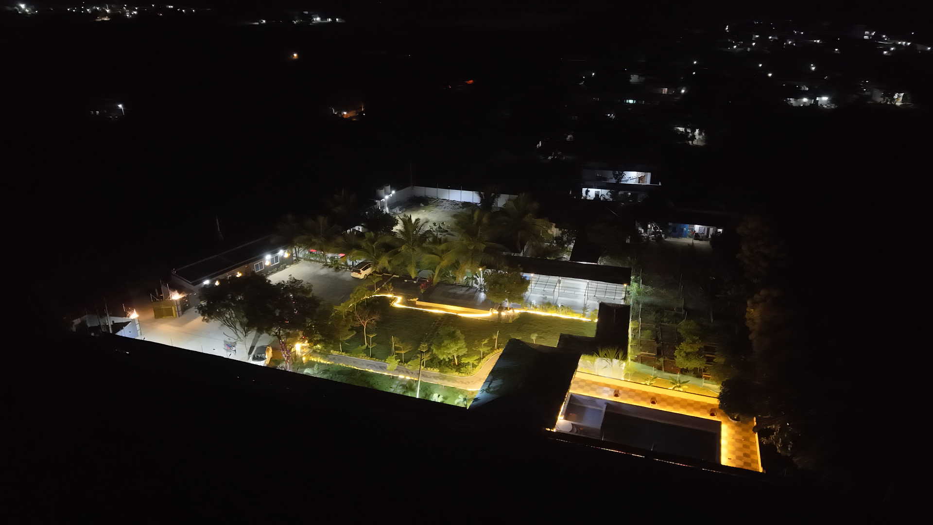 The estate glowing after dark, seen from above.