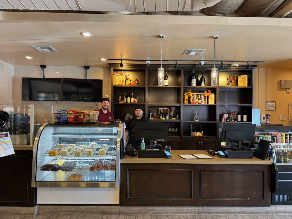 Meritage Wine Mart counter with team members, deli case, and wine shelves
