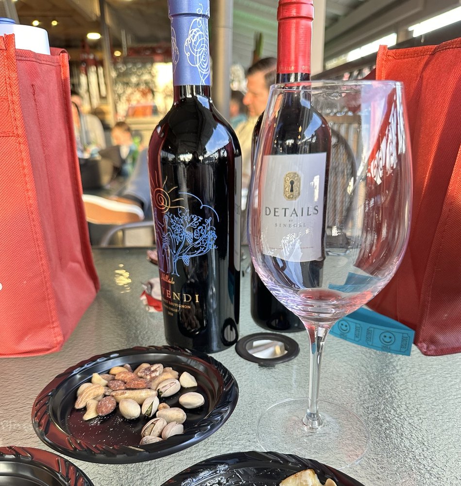 Wine bottles and a tasting glass in warm afternoon light