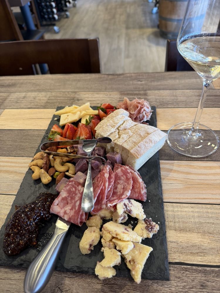 A cheese and charcuterie board with wine
