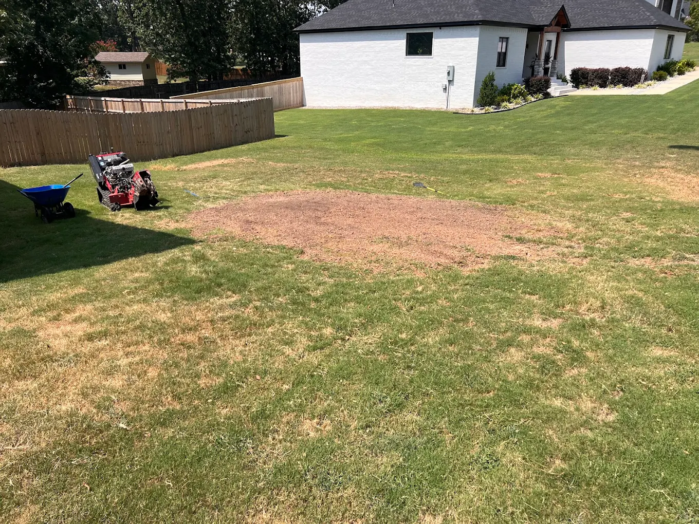 Completed stump grinding job showing clean mulch area in residential backyard