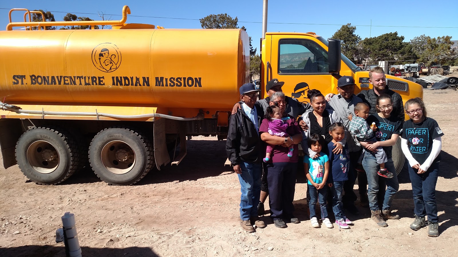 Delgaritos family with Paper for Water volunteers next to a water truck