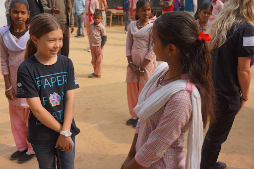 Isabelle Adams in Paper for Water shirt talking with an Indian girl
