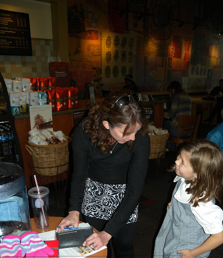 Katherine and Isabelle at Starbucks exchanging origami for donations