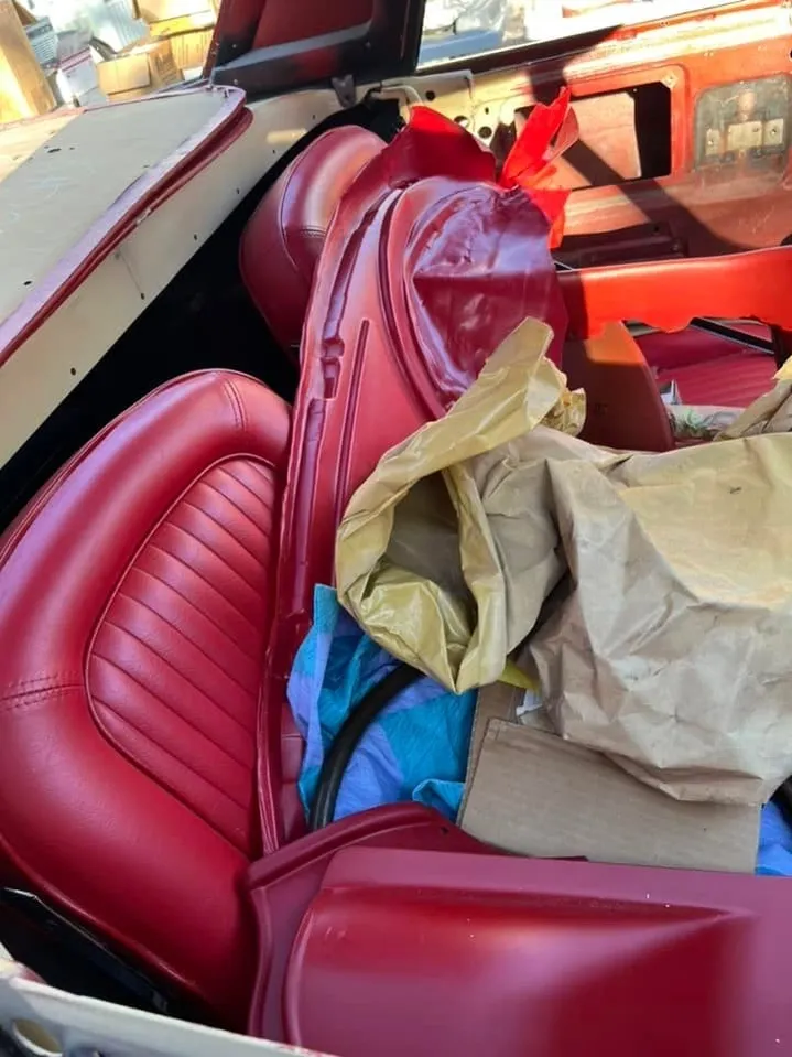 Original red leather bucket seats in a classic convertible interior