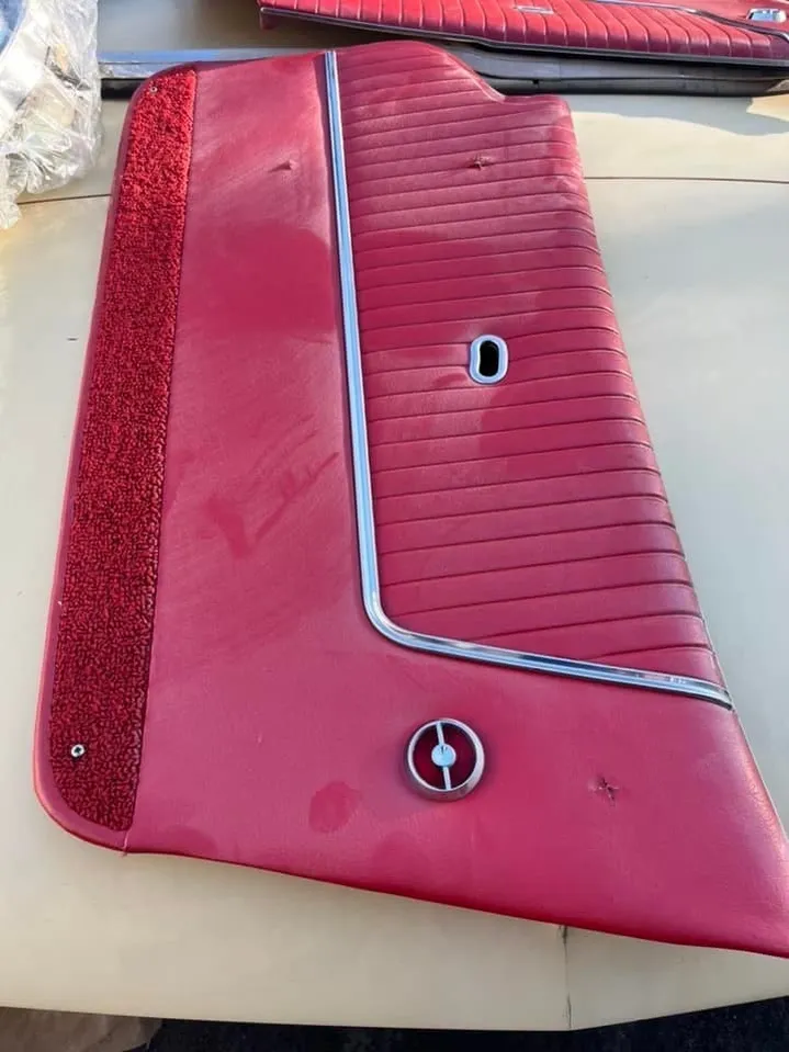 Original red door panel with chrome trim strip and Corvette emblem