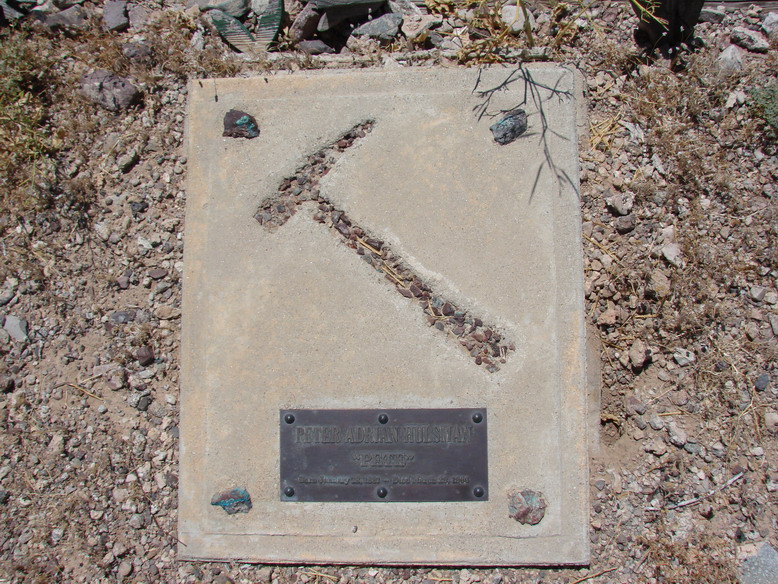 Peter Adrain Hulsman's grave marker, set into a concrete slab in the desert