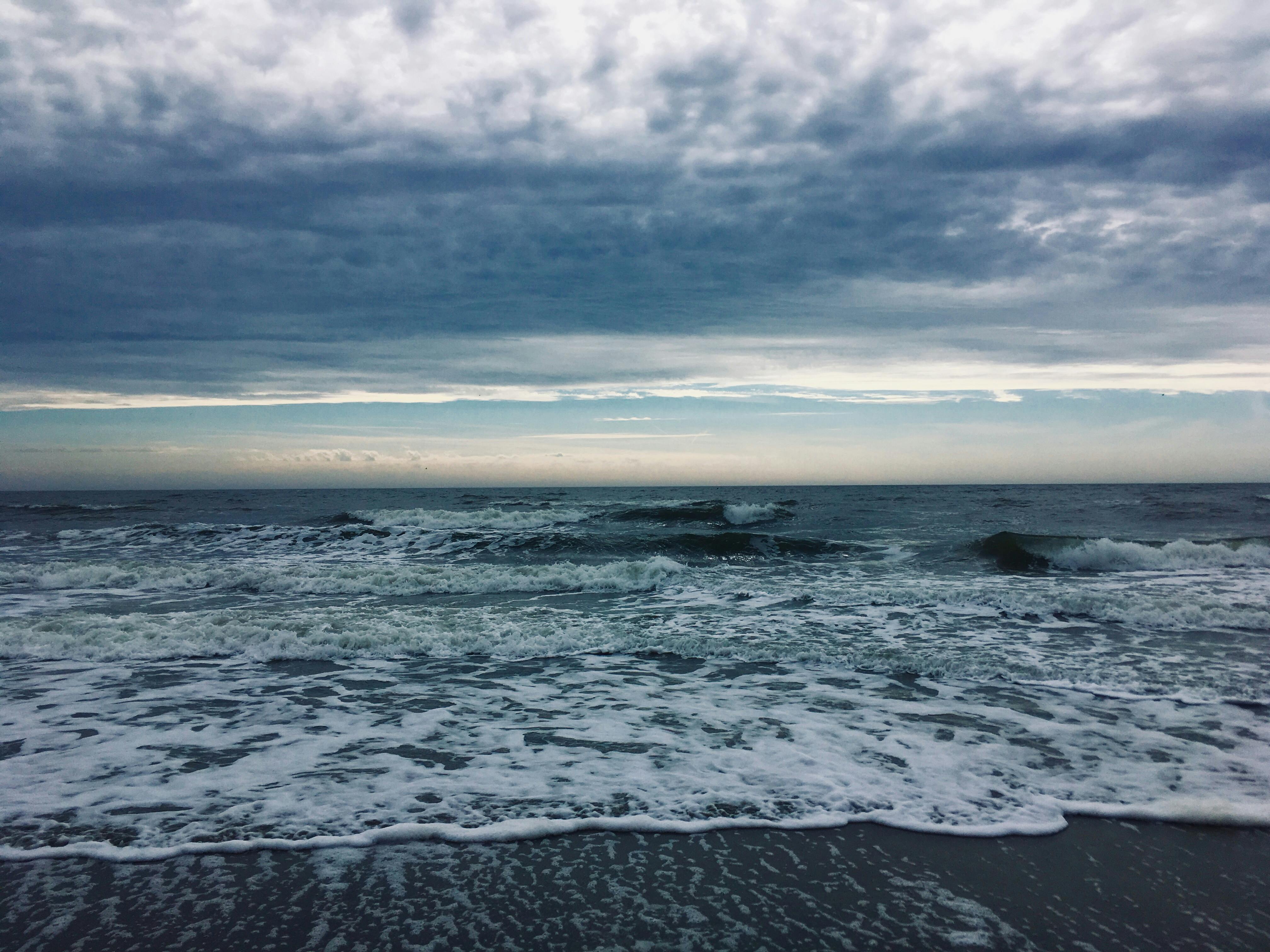 Dramatic ocean waves under stormy sky