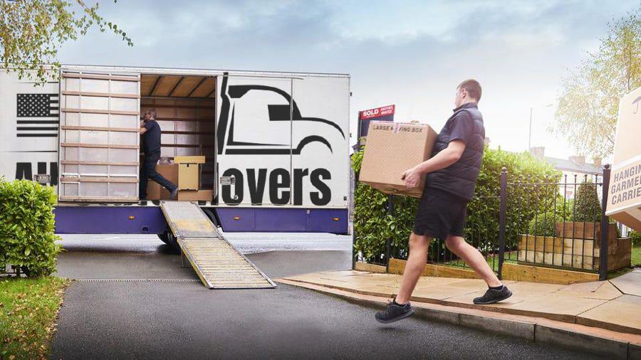 Professional movers loading boxes into moving truck