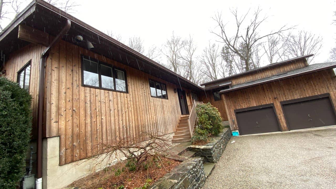 Gutter replacement on rustic wood siding ranch home with dark fascia — Connecticut