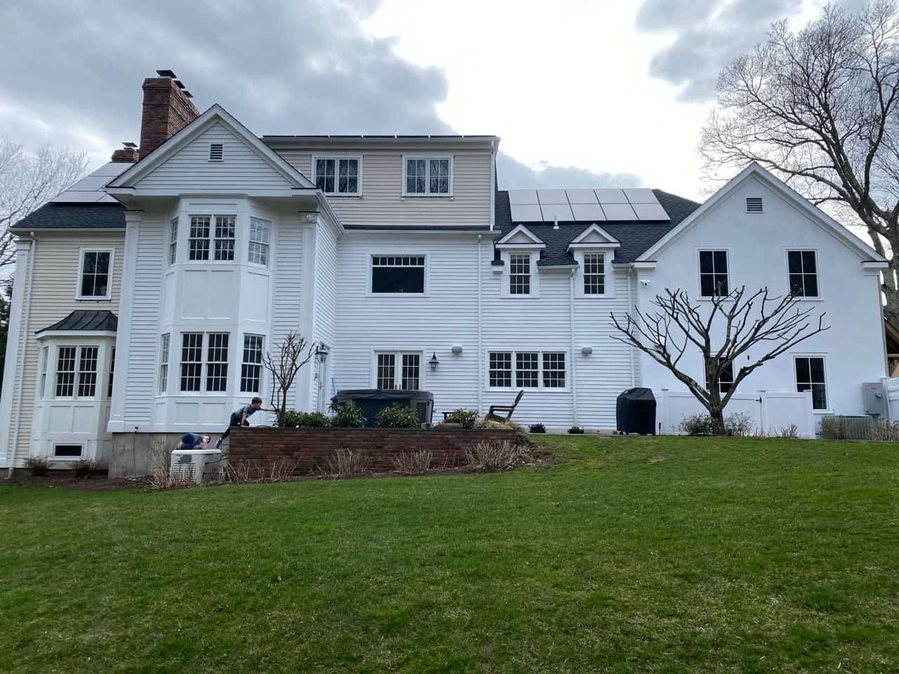 Large white colonial estate with solar panels — gutter installation Westchester CT