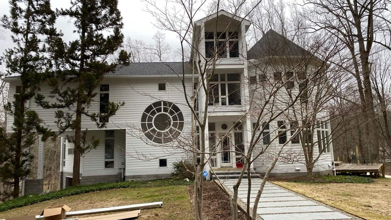 White gutter system on unique multi-story home with circular window and tower — Connecticut