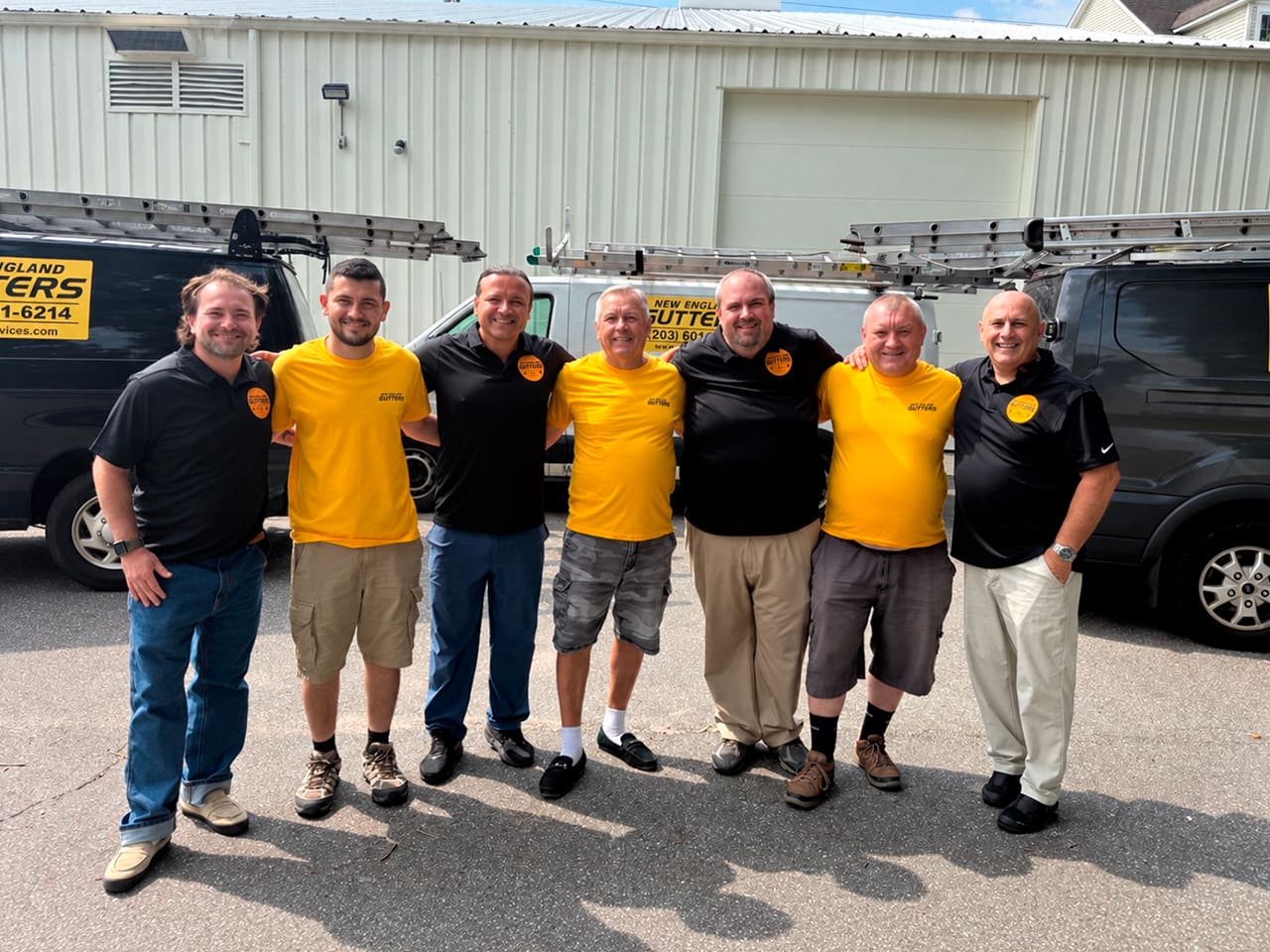 New England Gutter Services team standing together in front of company vehicles