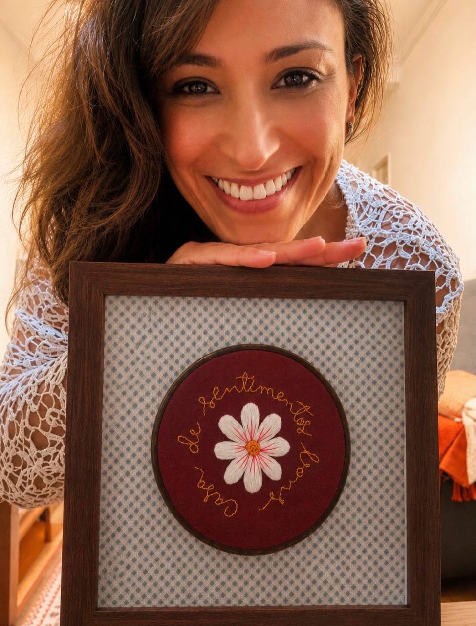 Mulher sorrindo com um trabalho de bordado