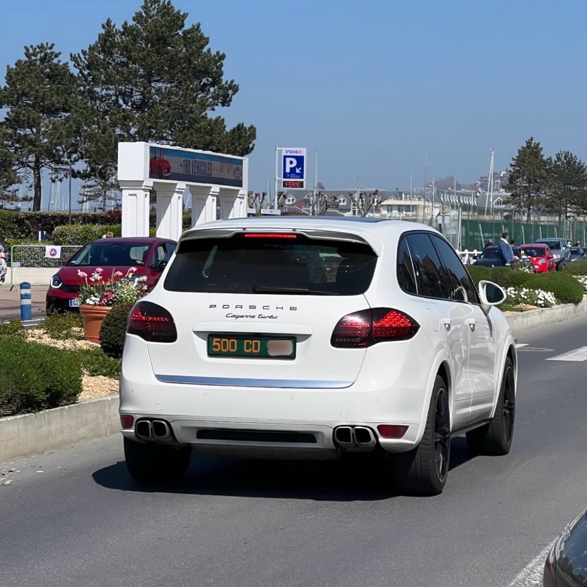 Plaque 500 CD — Porsche Cayenne Turbo blanc Plaque diplomatique verte 500 CD sur un Porsche Cayenne Turbo blanc roulant sur une avenue — code 500 hautes personnalités