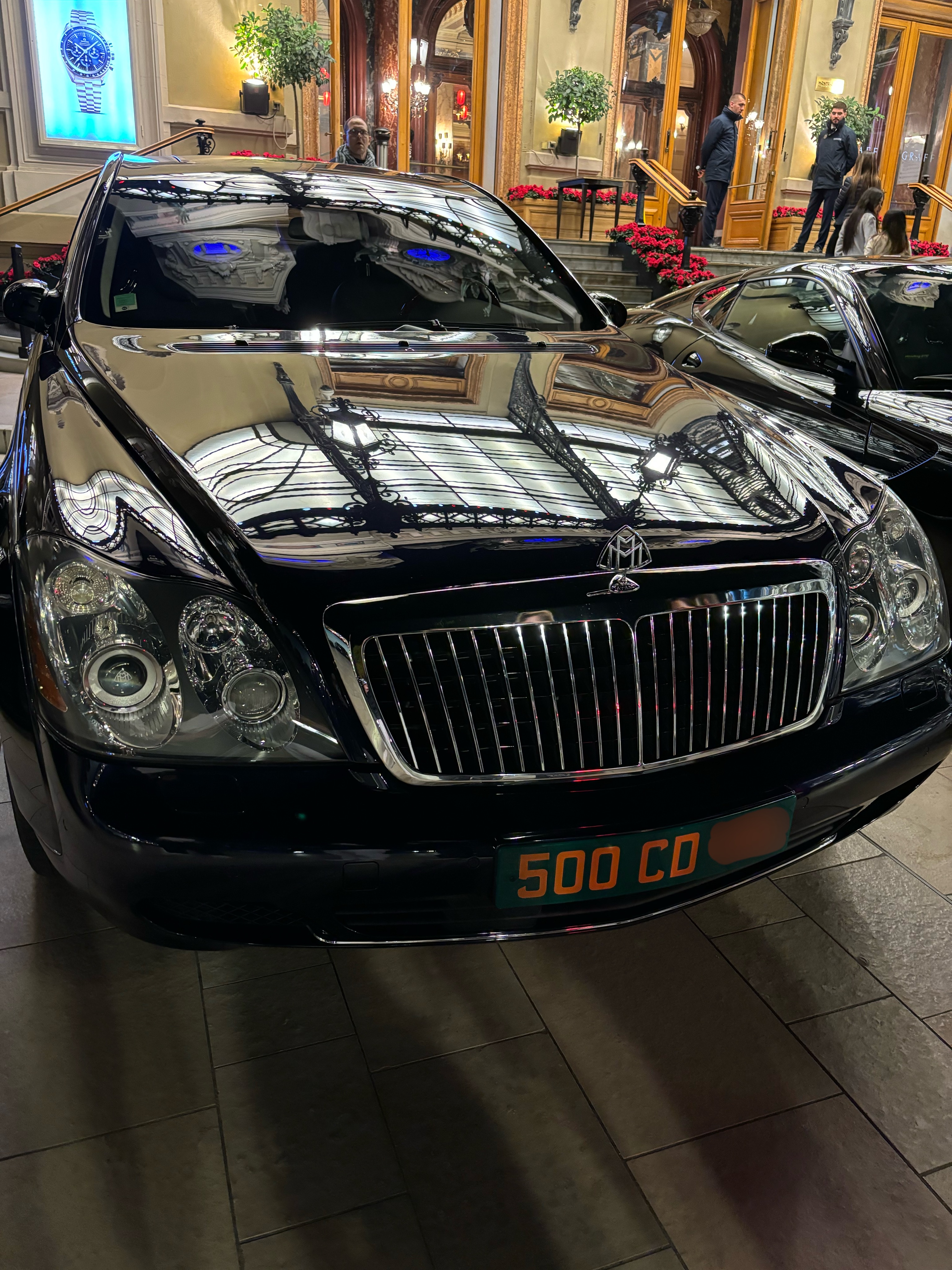 Plaque 500 CD — Maybach noire devant un palace parisien Plaque diplomatique verte 500 CD sur une Maybach noire garée devant un palace parisien illuminé — code 500 hautes personnalités