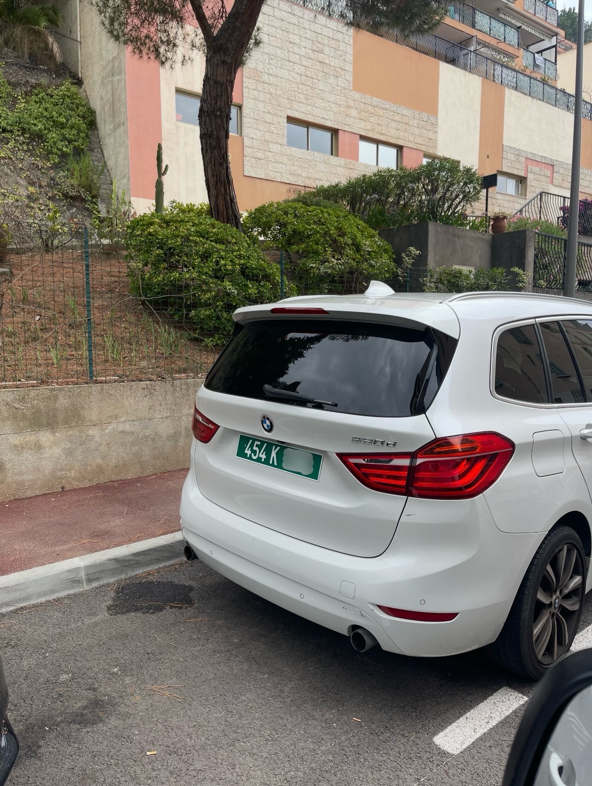 Plaque 454 K — ITER (Cadarache), BMW blanc Plaque diplomatique verte 454 K sur un BMW 2 Series Active Tourer blanc garé dans un parking ensoleillé — code 454 ITER
