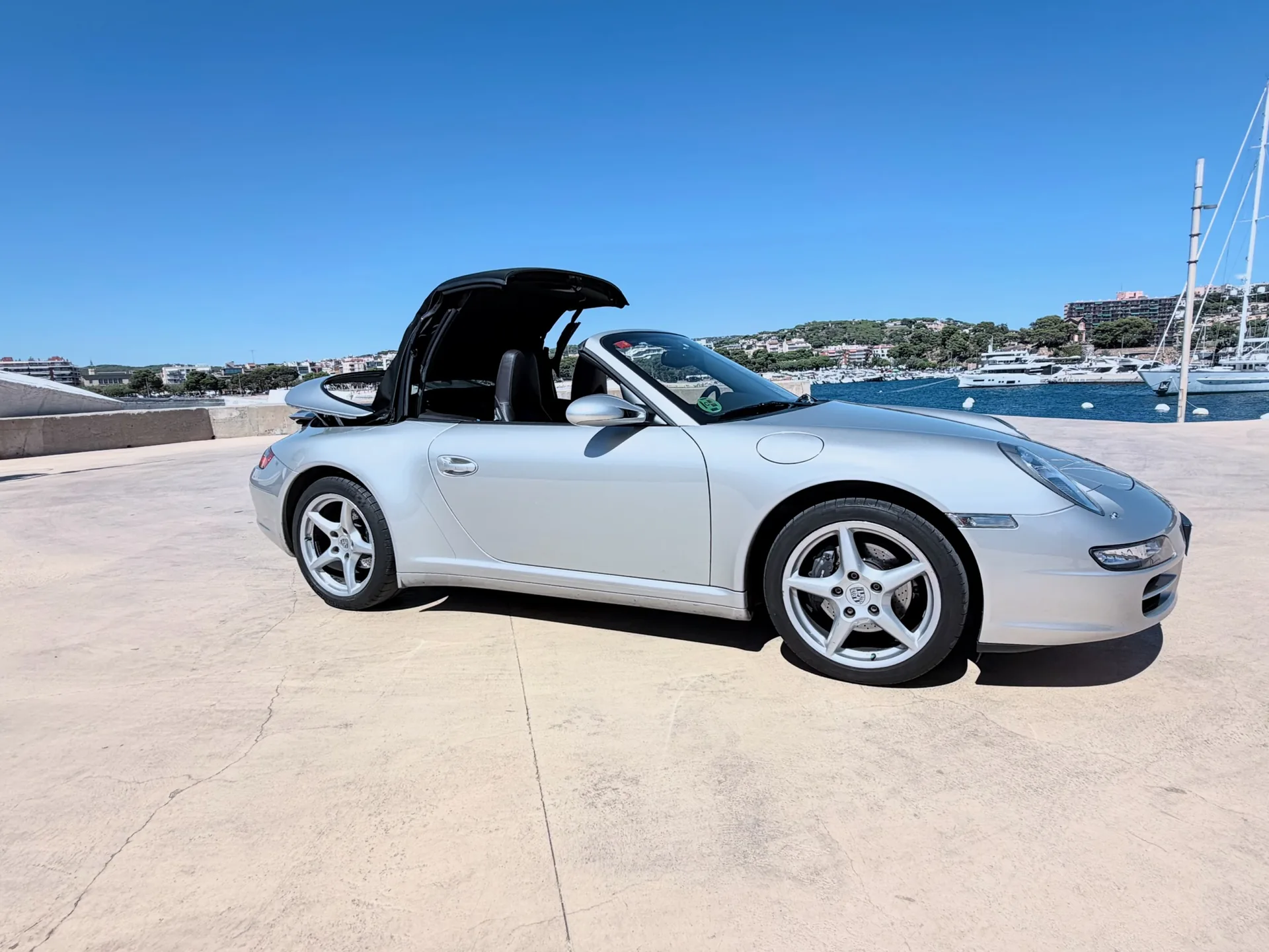 Complete front three-quarter view of the Porsche 911 Carrera 4 Cabriolet with the roof in motion